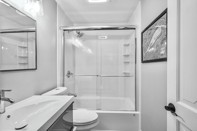 full bathroom featuring toilet, combined bath / shower with glass door, and vanity