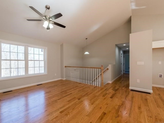 empty room with ceiling fan, light wood-type flooring, and lofted ceiling