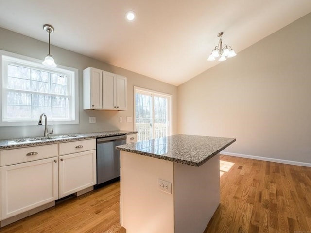 kitchen with sink, stainless steel dishwasher, white cabinetry, a center island, and a wealth of natural light