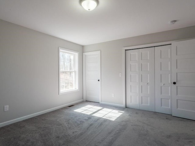 unfurnished bedroom with a closet and carpet flooring