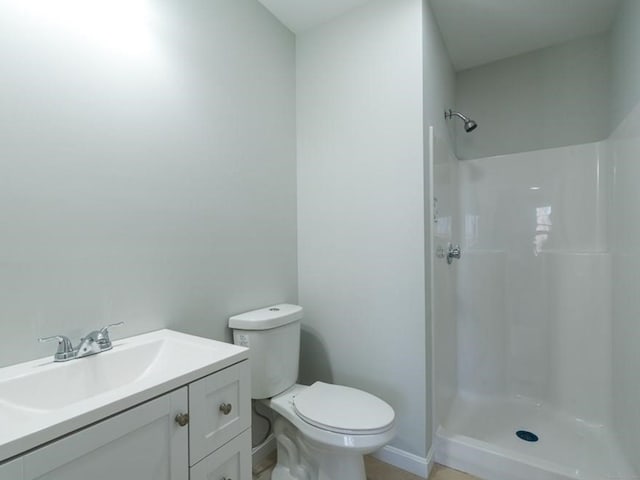 bathroom featuring a shower, vanity, and toilet