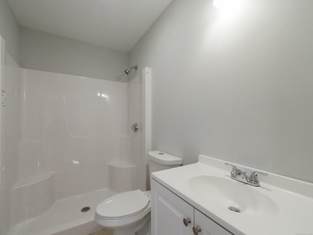 bathroom featuring a shower, vanity, and toilet