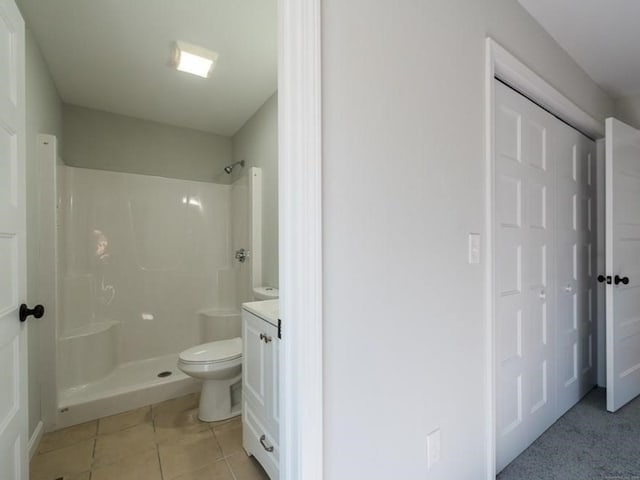 bathroom with toilet, walk in shower, vanity, and tile patterned floors