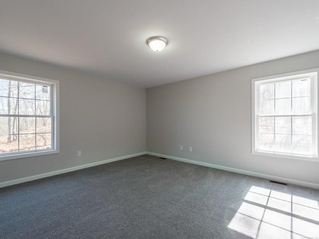 unfurnished room with dark colored carpet