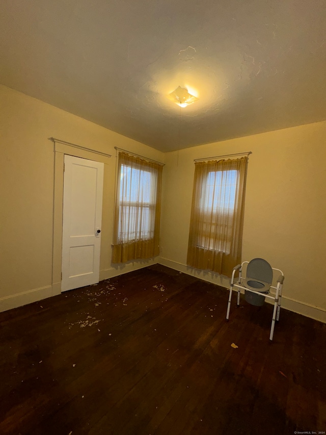 empty room with dark hardwood / wood-style flooring