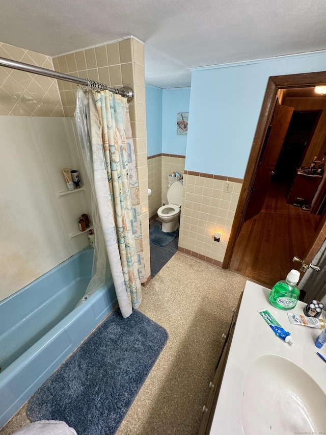 bathroom featuring toilet, tile walls, wainscoting, and shower / bath combination with curtain