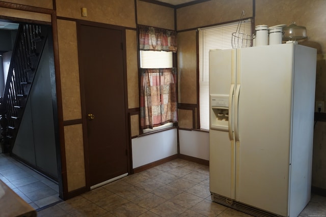 kitchen with pendant lighting, light tile patterned floors, and white refrigerator with ice dispenser