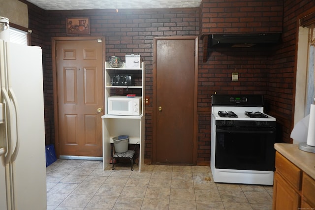 kitchen with brick wall, light tile patterned floors, white appliances, and range hood