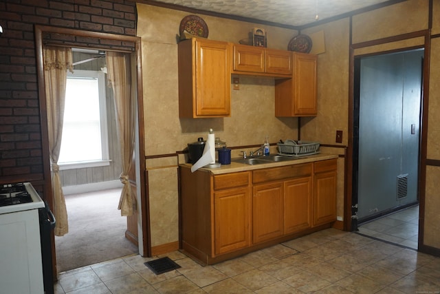 kitchen featuring white range, sink, a textured ceiling, and light carpet