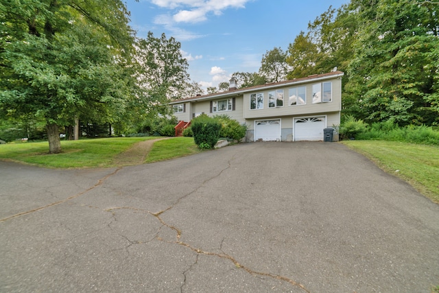 raised ranch with central AC, a front yard, and a garage