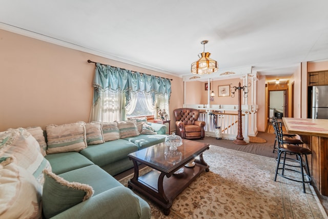 living room with ornamental molding, a notable chandelier, and carpet floors