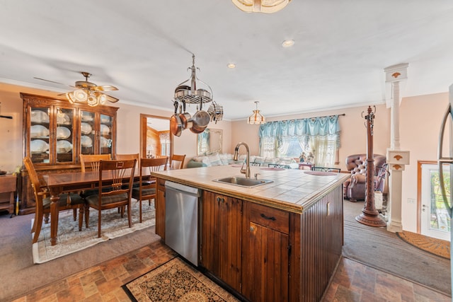 kitchen with sink, ornamental molding, a center island with sink, dishwasher, and tile countertops