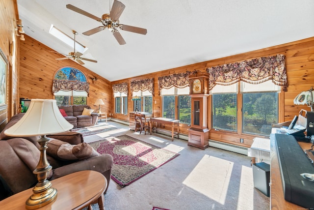 sunroom with a healthy amount of sunlight, ceiling fan, a baseboard radiator, and vaulted ceiling with skylight