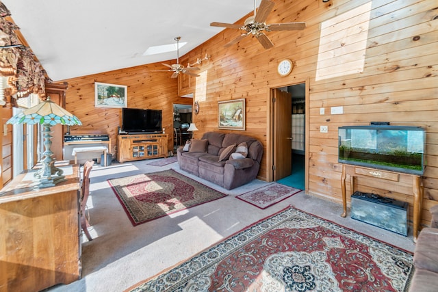 carpeted living room featuring ceiling fan, wood walls, and lofted ceiling with skylight