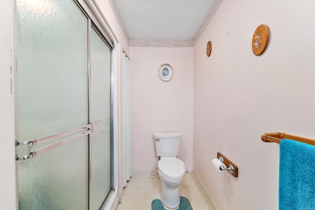 bathroom featuring an enclosed shower, toilet, and a textured ceiling