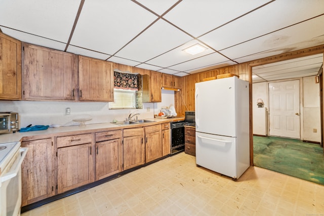 kitchen with wooden walls, sink, and black appliances