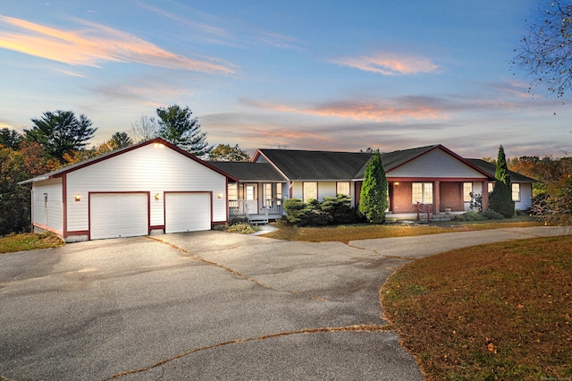 single story home featuring an attached garage, driveway, and a porch