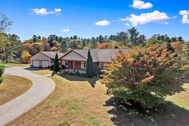 single story home with a front lawn, driveway, and a detached garage
