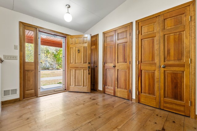 entryway with light hardwood / wood-style flooring, lofted ceiling, and a wealth of natural light