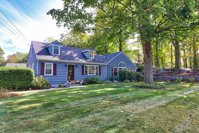 cape cod home featuring a front yard