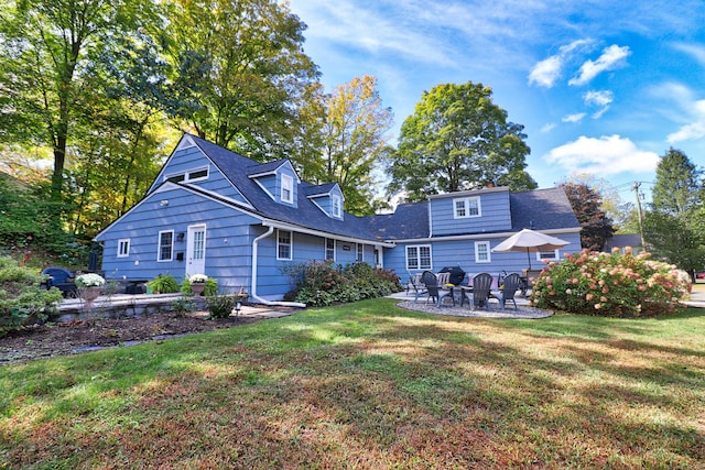 back of property featuring a yard and a patio area