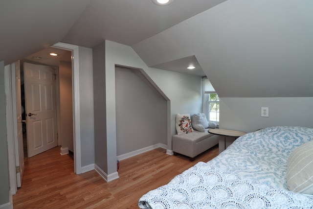 bedroom featuring light wood-type flooring and vaulted ceiling