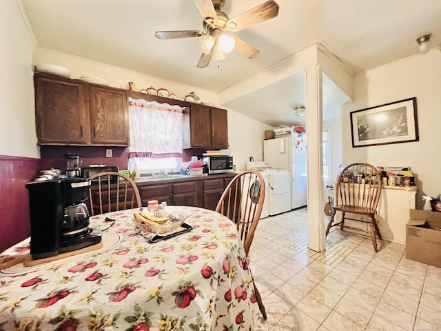 dining space featuring sink, ceiling fan, ornamental molding, and washing machine and clothes dryer