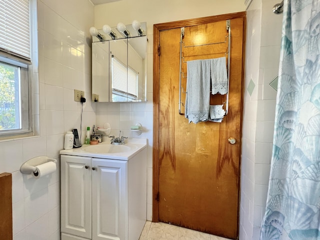 bathroom featuring vanity and tile walls