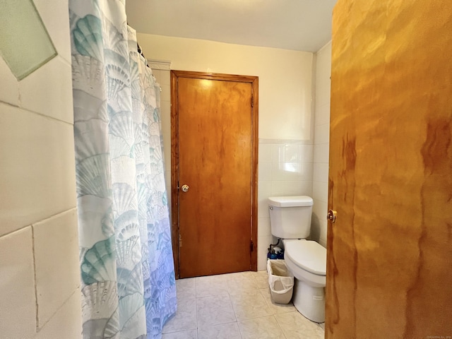 bathroom with tile patterned flooring, tile walls, and toilet