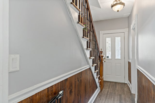 entrance foyer featuring hardwood / wood-style flooring, wooden walls, and a textured ceiling