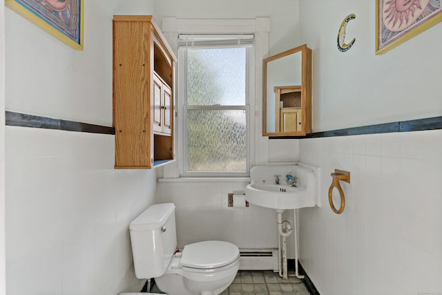 bathroom with a healthy amount of sunlight, a baseboard radiator, toilet, and tile walls