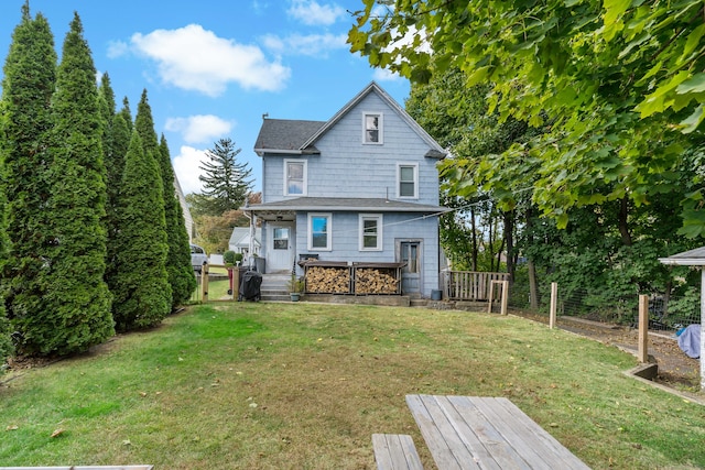 back of house featuring a lawn and a wooden deck