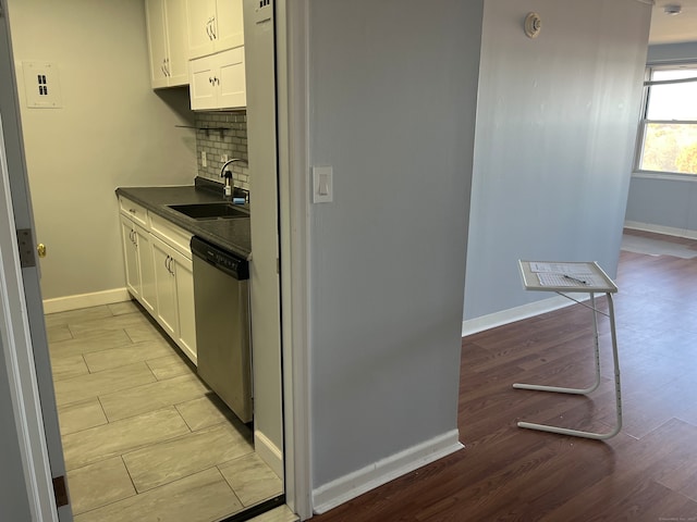 kitchen featuring dishwasher, light hardwood / wood-style floors, white cabinetry, and sink