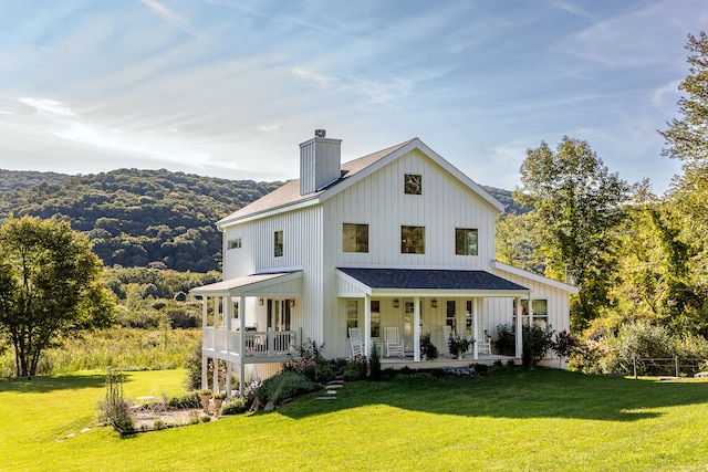 rear view of property with a yard and a porch