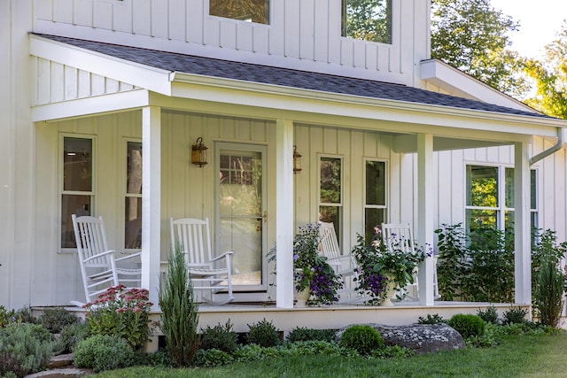 doorway to property featuring a porch, roof with shingles, and board and batten siding