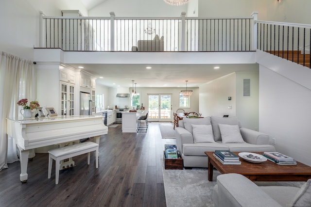 living room with a notable chandelier, dark hardwood / wood-style floors, and a high ceiling