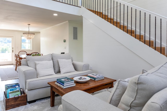 living area with visible vents, a notable chandelier, ornamental molding, recessed lighting, and stairs