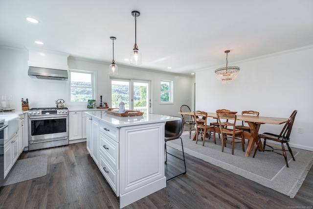 kitchen featuring a kitchen island, dark wood-type flooring, decorative light fixtures, stainless steel range oven, and white cabinetry