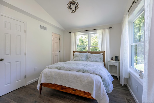 bedroom featuring visible vents, multiple windows, wood finished floors, and lofted ceiling