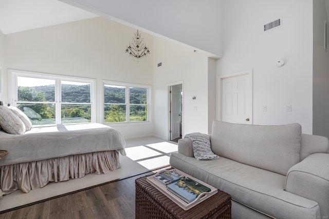 bedroom with high vaulted ceiling, multiple windows, and wood-type flooring