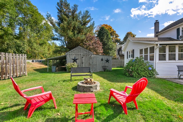 view of yard with an outdoor fire pit and a storage unit