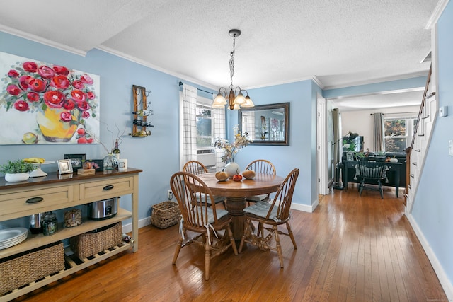 dining room featuring ornamental molding, hardwood / wood-style flooring, a notable chandelier, and a wealth of natural light