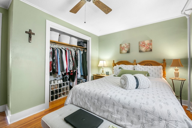 bedroom with a closet, light hardwood / wood-style flooring, ornamental molding, and ceiling fan