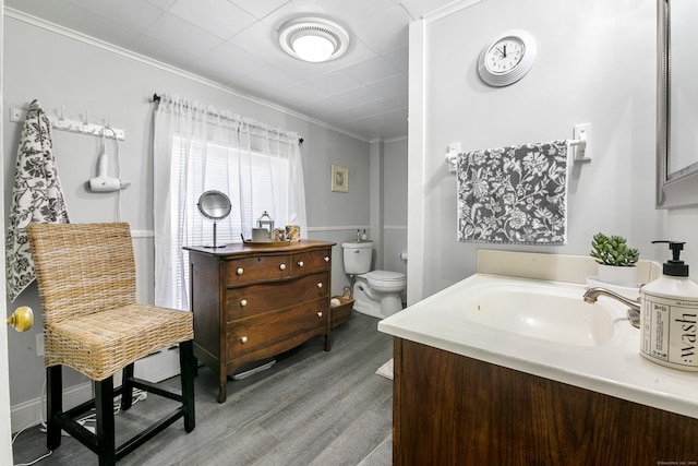 bathroom featuring crown molding, sink, toilet, and wood-type flooring