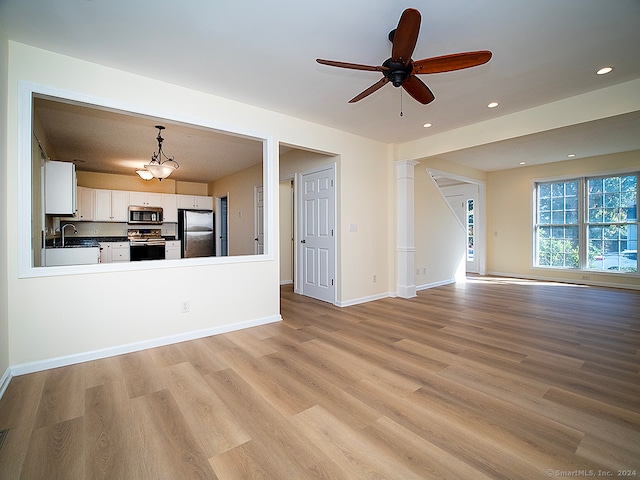 unfurnished living room with ceiling fan, sink, and light hardwood / wood-style flooring