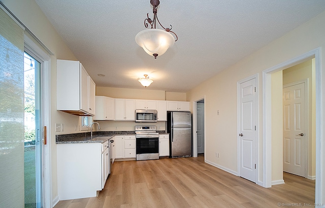 kitchen featuring light hardwood / wood-style flooring, sink, hanging light fixtures, appliances with stainless steel finishes, and white cabinetry