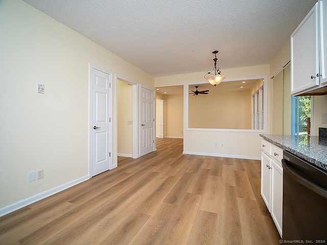 kitchen with black dishwasher, stone countertops, light wood-type flooring, and white cabinetry