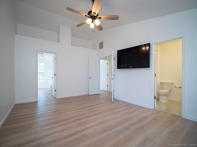 unfurnished bedroom featuring light hardwood / wood-style floors, vaulted ceiling, ensuite bathroom, and ceiling fan