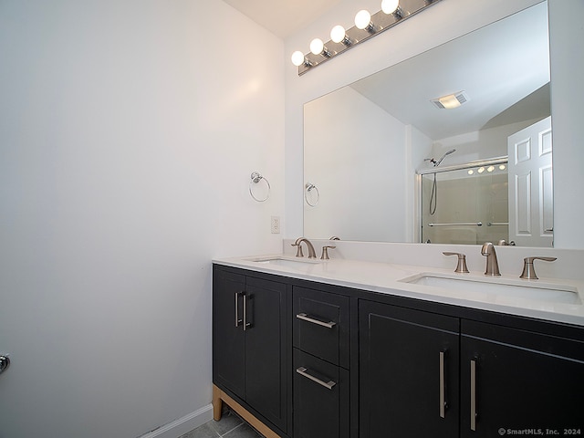 bathroom featuring a shower with door, tile patterned floors, and vanity