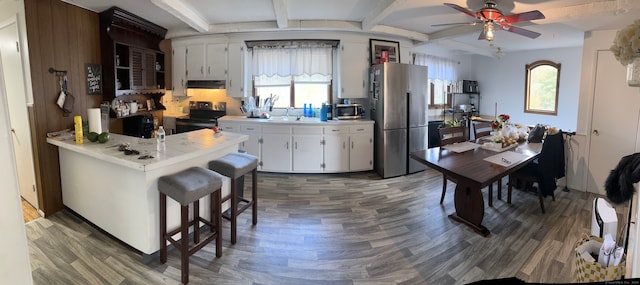 kitchen with white cabinetry, a healthy amount of sunlight, stainless steel refrigerator, and black range with electric cooktop